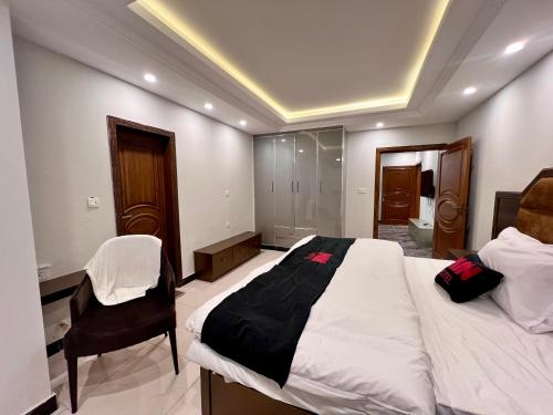 a bedroom with a bed and a chair in it at Mehboob international hotel murree in Murree