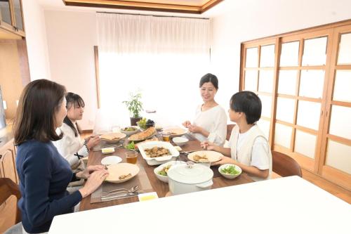 a group of people sitting around a table eating food at Kazeno Ryoan Fuga-風乃旅庵 楓雅 in Koshu