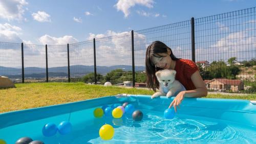 a young girl playing with a teddy bear in a pool at Gyeongju Forest 258 Pet-friendly Pool Villa in Gyeongju