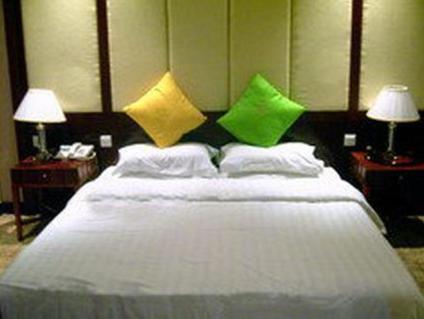a bedroom with a white bed with green and yellow pillows at 1ST Homestay - HK Tai Wan Hostel in Hong Kong