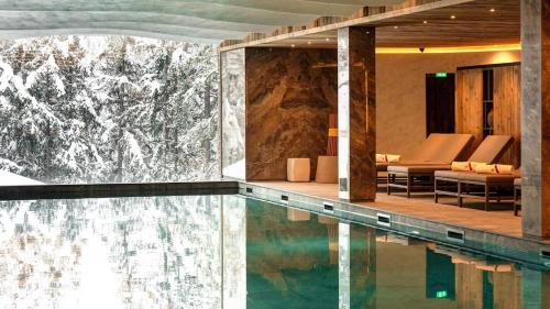 - une piscine dans un hôtel avec des chaises et une table dans l'établissement Antarès Méribel Luxury Apartment, à Les Allues