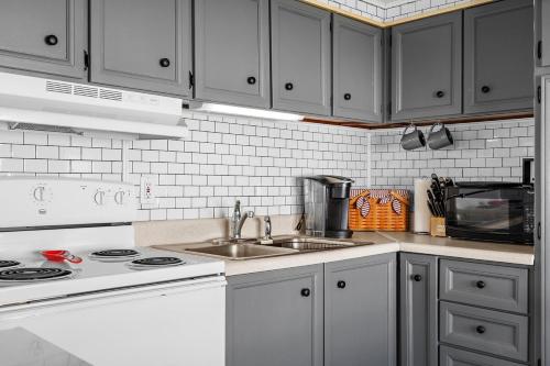 a white kitchen with a sink and a stove at Peaceful Nokomis Escape 5 Mins to Beach 55 in Nokomis