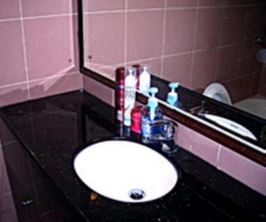 a bathroom with a sink and a black counter at 1ST Homestay - HK Tai Wan Hostel in Hong Kong