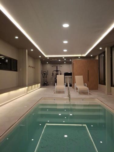 a swimming pool in a building with chairs and a table at Hotel boutique Tramas Andinas in Salta