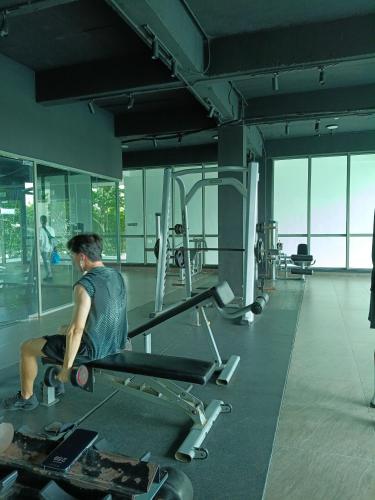 a man sitting on a bench in a gym at Peace home apex in Cyberjaya