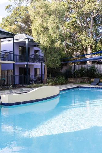 a large blue swimming pool in front of a building at Moo's Hoose in Margaret River Town