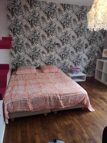 - une chambre avec un lit et un mur recouvert de papier peint dans l'établissement Chez nous, à La Celle-sous-Gouzon