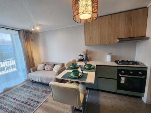 a kitchen and living room with a table and a couch at Departamento Puerto Montt in Puerto Montt