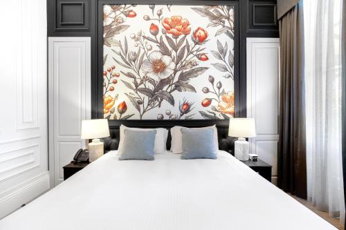 a bedroom with a large white bed with a floral wallpaper at Marnong Estate in Mickleham