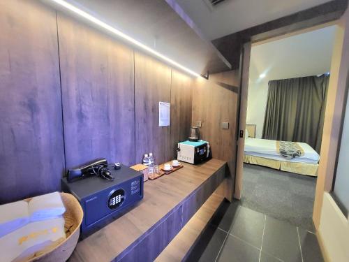 a room with a room with a bed and a radio at Roxy Hotel & Apartments in Kuching
