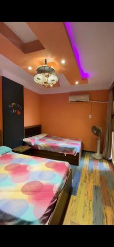 a room with two beds and a ceiling with purple lights at العجمي البيطاش شهر العسل مدينة درويش السياحية شاطيء ميكا in Alexandria