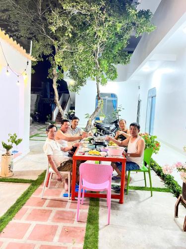 een groep mensen die rond een tafel zitten bij Phú Quý MYNO Homestay in Cu Lao Thu