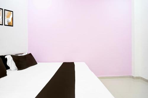 a white bedroom with a black and white bed at SPOT ON Hotel Vardaan in Prayagraj