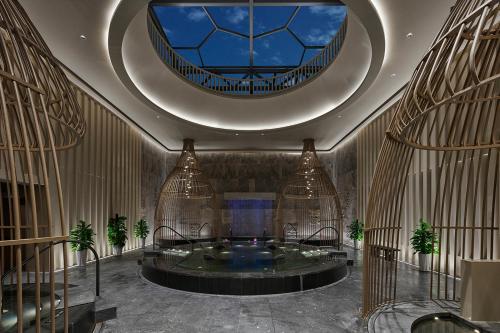 a large lobby with a large tub in a building at Homm Changchun Beihu in Changchun