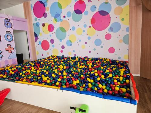 a bed covered in lots of balls in a room at Gran Paradiso Campos do Jordão - Resort in Campos do Jordão