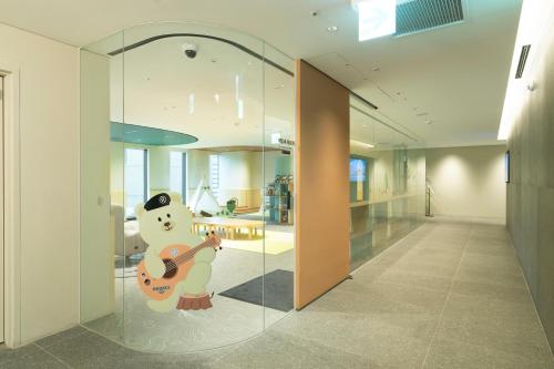 a glass wall in a hallway with a guitar at Nine Tree Premier ROKAUS Hotel Seoul Yongsan in Seoul