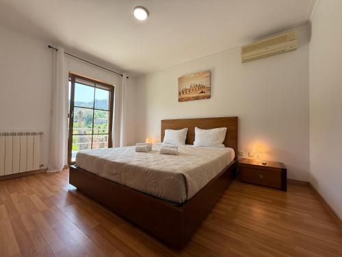 a bedroom with a large bed and a window at Casa Terra Nova - Gerês in Terras de Bouro