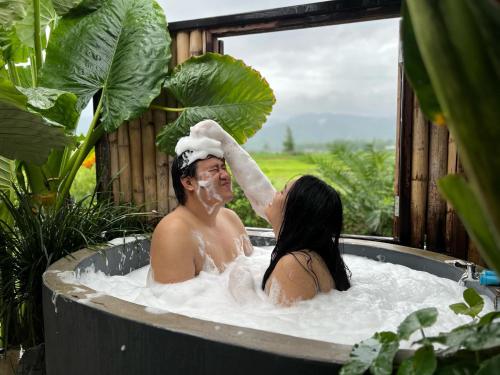 a man and a woman in a bath tub at DeeTorJai FarmStay Nan ดีต่อใจ ฟาร์มสเตย์ น่าน โดยเจ้าของ in Ban Klang