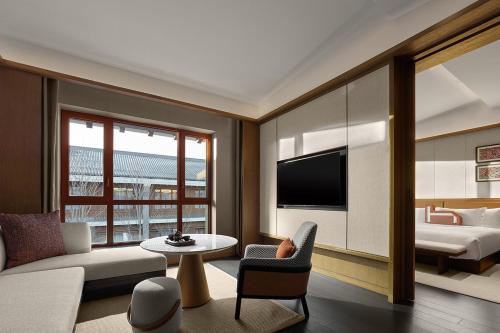 a living room with a couch and a bed at Homm Changchun Beihu in Changchun
