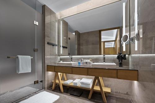 a bathroom with two sinks and a large mirror at Homm Changchun Beihu in Changchun