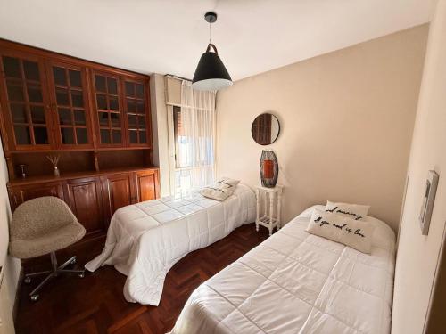 a bedroom with two beds and a chair at Decimo in Villa Mercedes