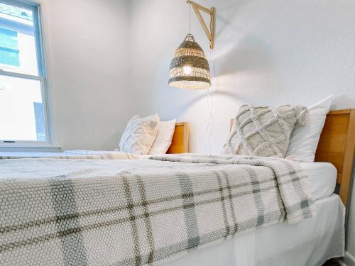 a bedroom with a bed with a blanket and a lamp at 2 Min Walk to Beach -Ocean View-Heated Pool-Modern in Poplar Branch