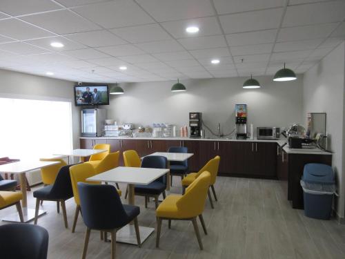 een restaurant met tafels en gele stoelen en een bar bij Comfort Inn & Suites Springfield in Springfield
