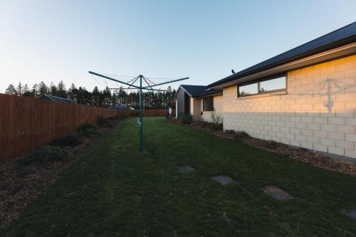 a pole in the grass next to a house at Just like home - Methven in Methven