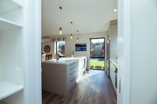 a kitchen with white cabinets and a large sink at Just like home - Methven in Methven