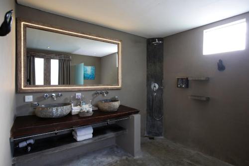 a bathroom with two sinks and a large mirror at Blue Karma Dijiwa Seminyak in Seminyak