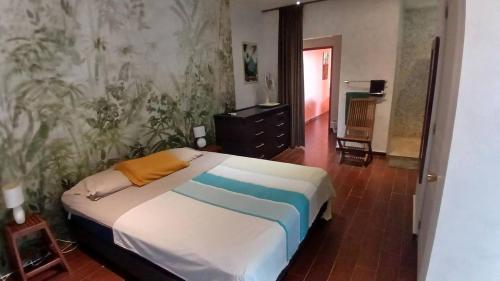 a bedroom with a bed and a wall with plants at Taapuna Guest House in Punaauia
