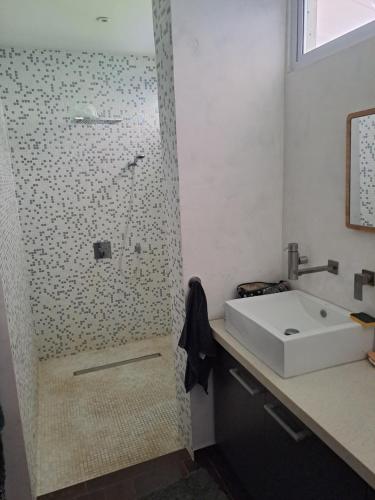 a bathroom with a sink and a shower at Taapuna Guest House in Punaauia
