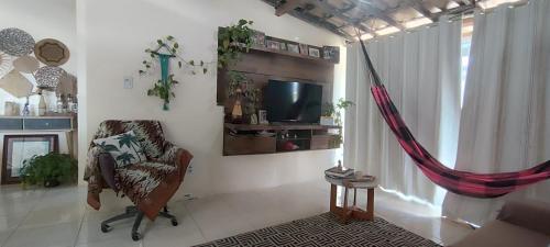 a living room with a chair and a television at Espaço Sol e Mar in Salvador