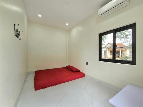 a red bed in a room with a window at Hang Camping 2 in An Ninh