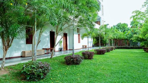 a green yard with trees and a building at CENTRAL BLANCHE Residence in Siem Reap