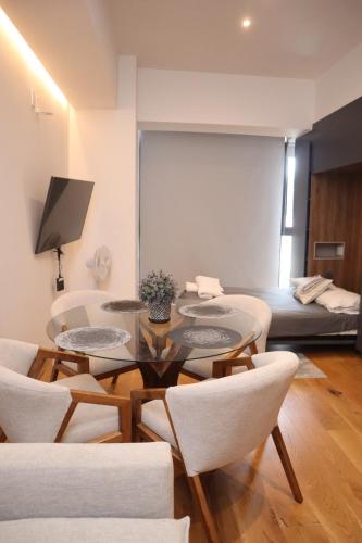 a living room with a table and chairs and a bed at Increíbles departamentos en Roma Norte in Mexico City