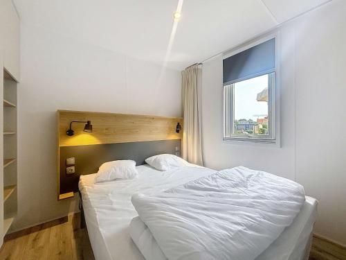 une chambre avec un lit blanc et une fenêtre dans l'établissement Mobil-home Grand Confort 4 pers, 2 ch, piscine chauffée à 200m de la plage - FR-1-361A-65, à Jullouville