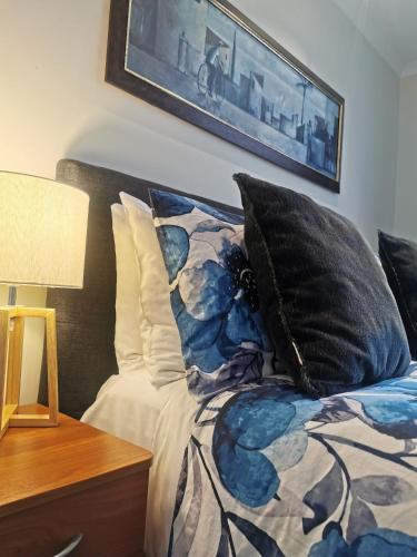 a bed with black pillows and a picture on the wall at ASURE Ascot Motor Inn in Taupo