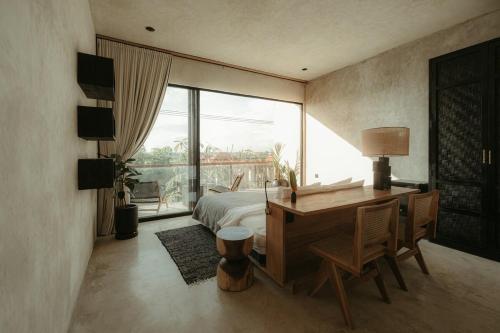 a bedroom with a desk and a bed and a window at The Iggy Hotel Seseh Studio 1 Sauna, Ice Bath in Cemagi