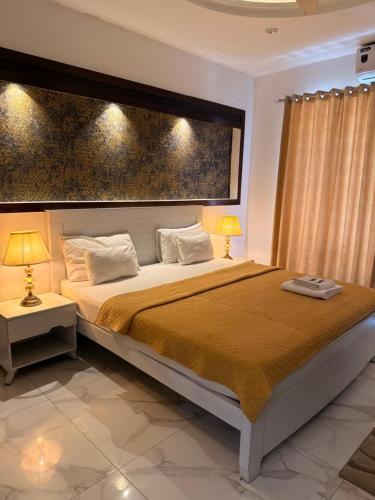 a bedroom with a large bed and two lamps at White House Executive - Guest House Islamabad in Rawalpindi