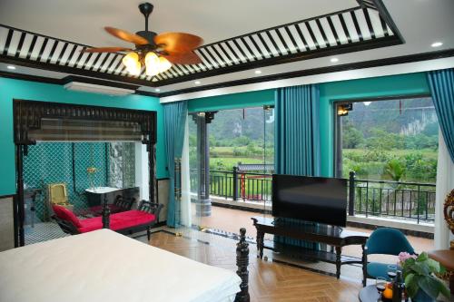 a living room with a bed and a balcony at Happy Tam Coc Ecolodge in Ninh Binh