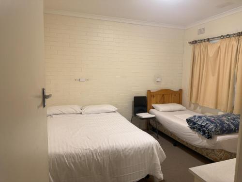 a room with two beds and a window at Ovensview On Riverside in Bright