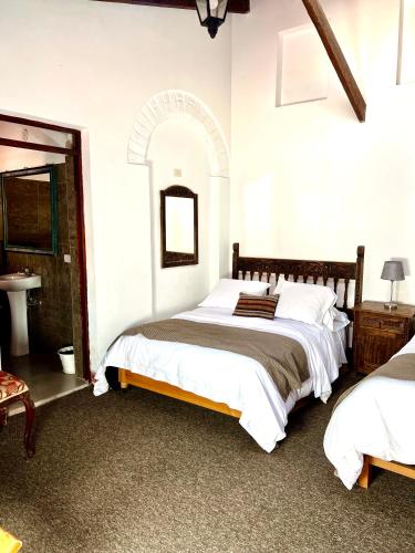 a bedroom with two beds and a sink at Inka Tambo Hacienda in Cusco