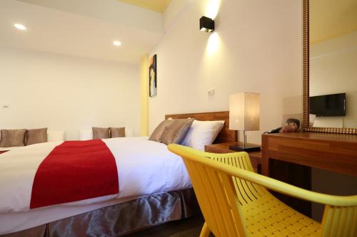 a bedroom with a bed and a desk and a chair at 角舍背包客棧 -近火車站 in Hualien City