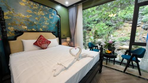 a bedroom with a bed with a large window at Happy Tam Coc Ecolodge in Ninh Binh