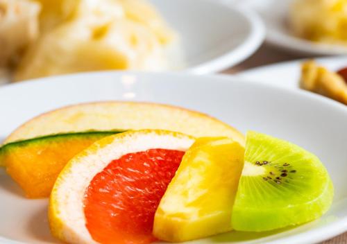 a white plate topped with slices of fruit on a table at APA Hotel Kanda Jimbocho Ekihigashi in Tokyo