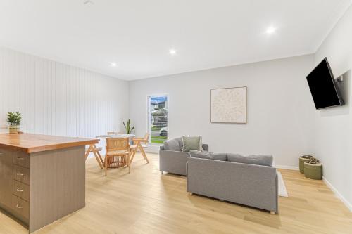 a living room with a couch and a table at The Sailfish Suite - Beachside Granny Flat by uHoliday in Kingscliff