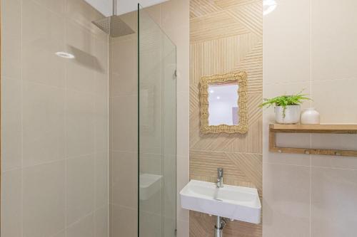 a bathroom with a sink and a glass shower at The Sailfish Suite - Beachside Granny Flat by uHoliday in Kingscliff