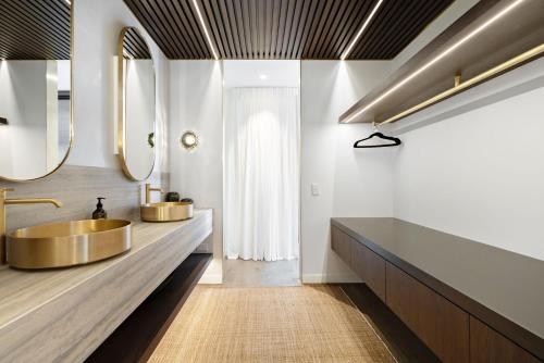 W łazience znajduje się złota umywalka i 2 lustra. w obiekcie The Bunkers Penthouse-2 Bed w mieście Queenstown