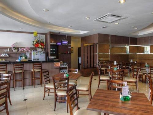 a restaurant with wooden tables and chairs and a bar at Country Hotel in Klang
